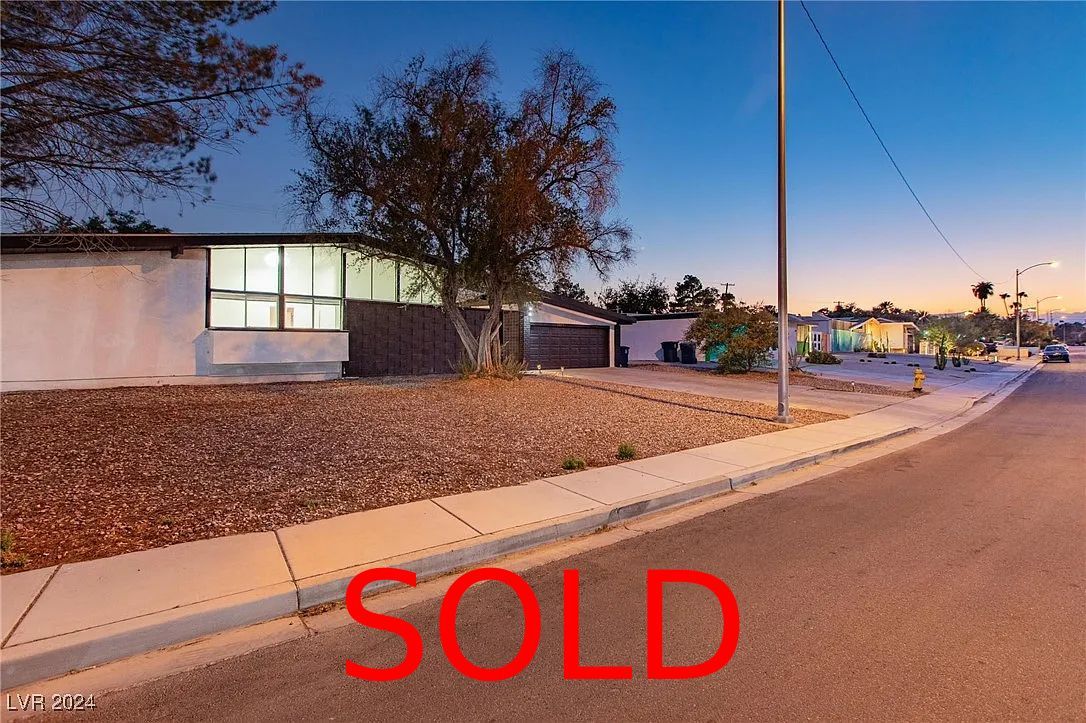 A living room with a couch , chairs , ottoman and a mirror