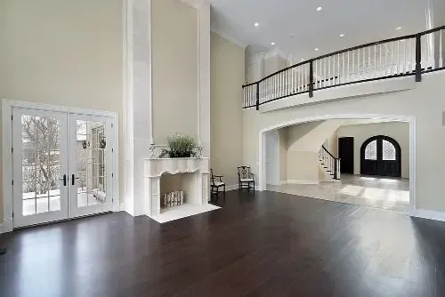 Beige sectional sofa in a living room with a TV, bookshelf, and artwork on the wall.