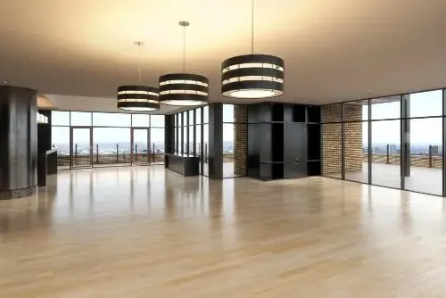 Cozy nursery with a crib, glider, dresser, and storage shelves. Beige walls and a window.