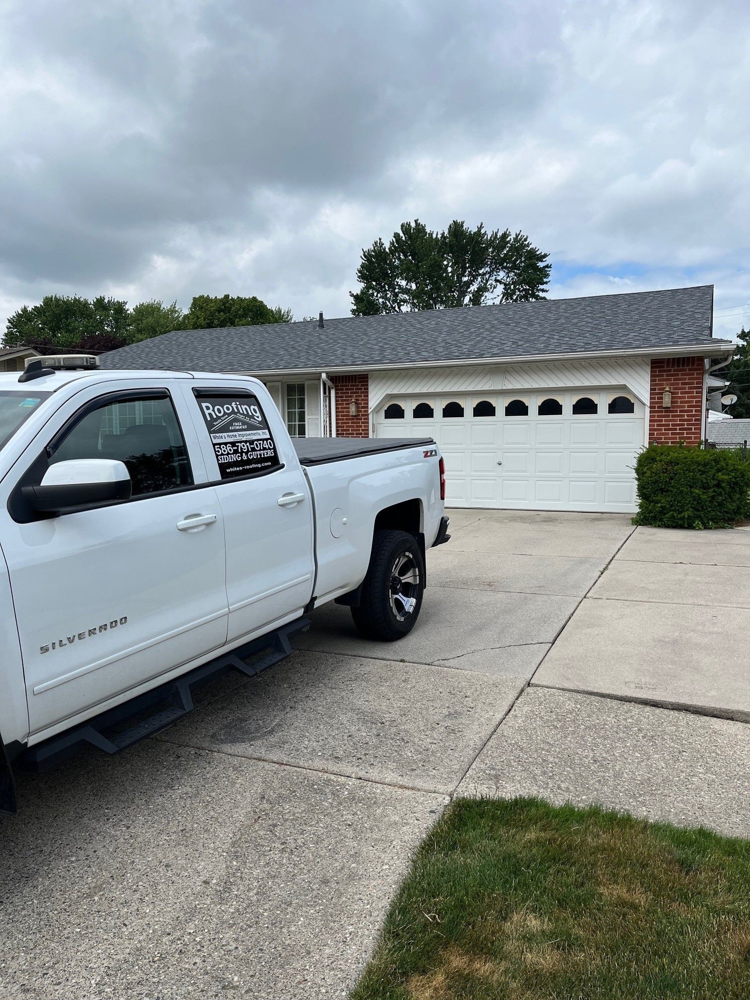 A white truck is parked in front of a house.