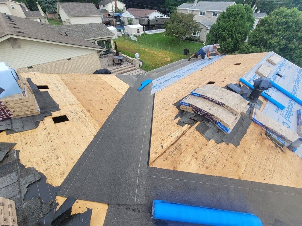 A man is working on the roof of a house.