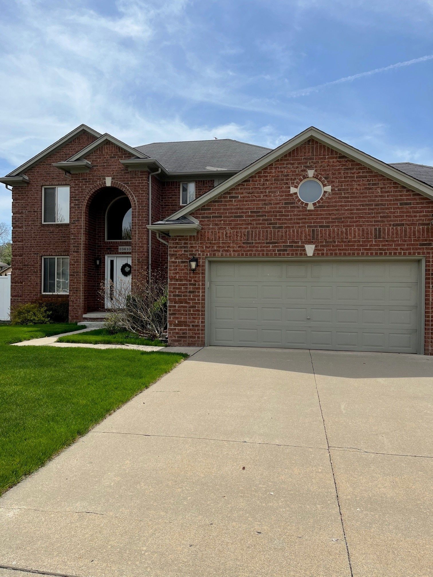 A large brick house with a gray garage door.