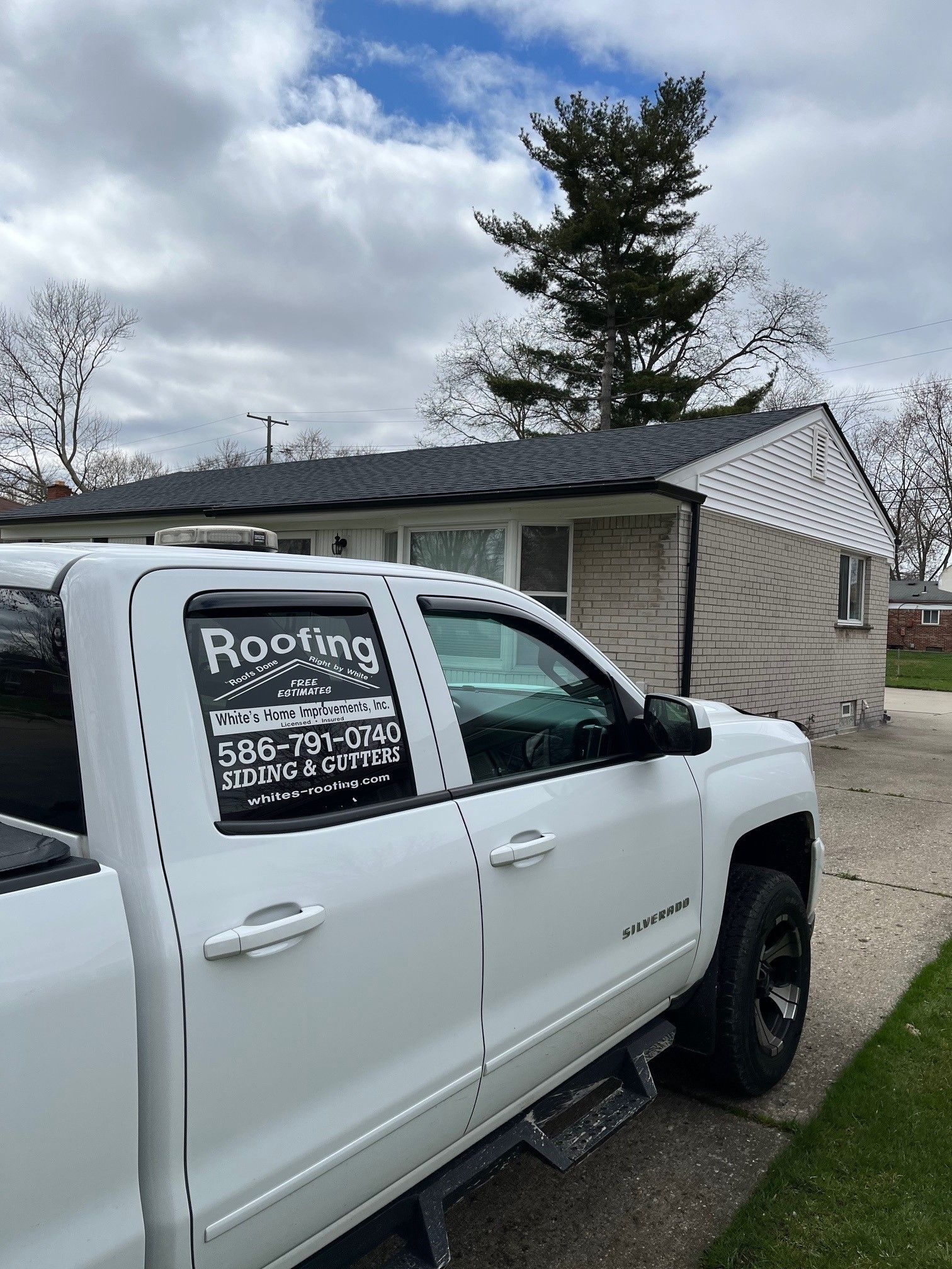 A white truck is parked in front of a house.