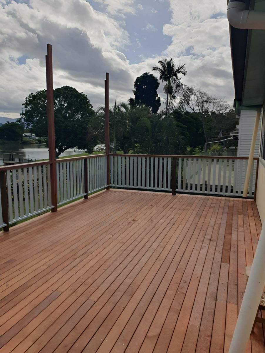A Wooden Deck With a White Railing and Trees in the Background — Offcut Carpentry In Murwillumbah, NSW