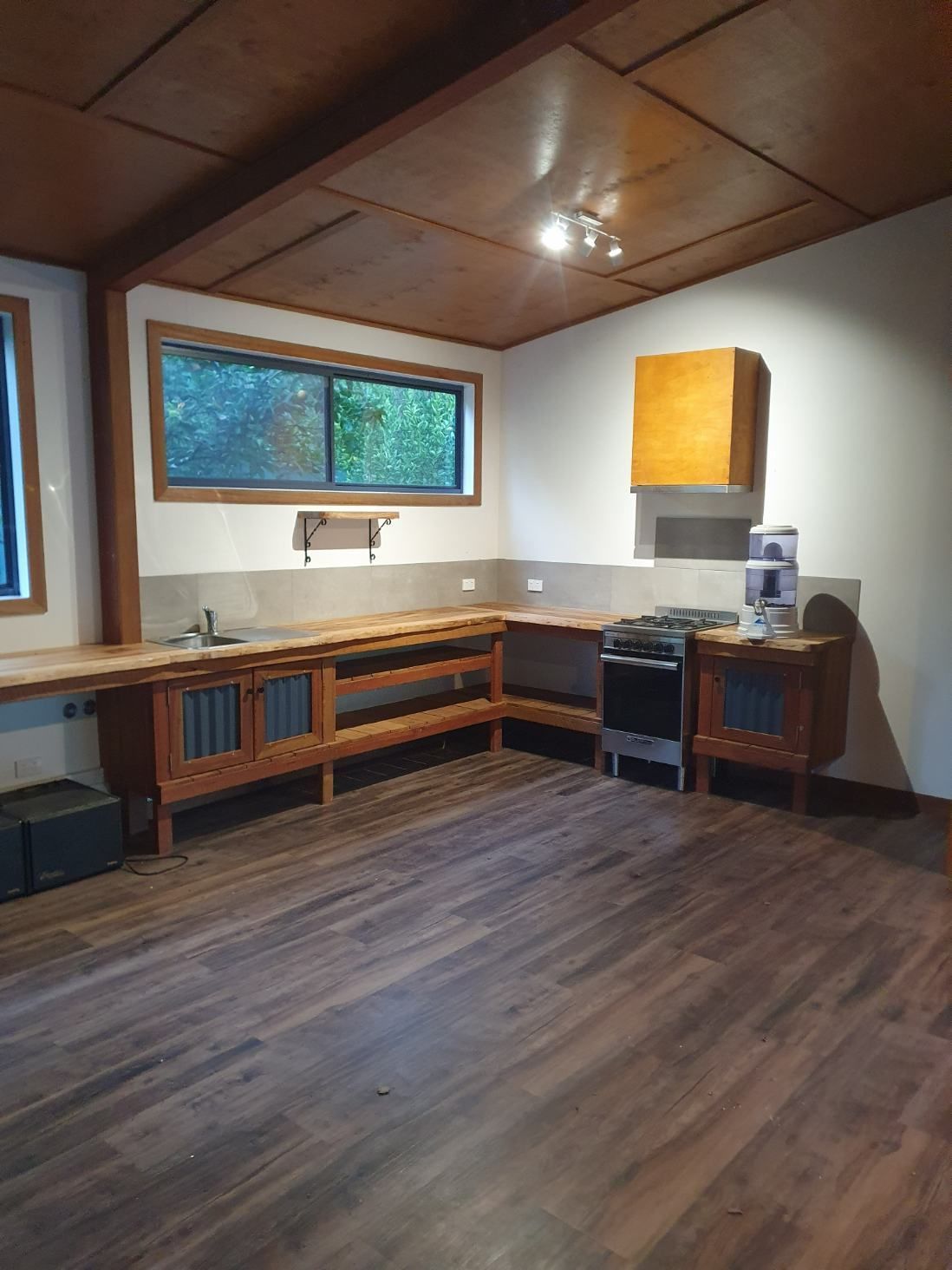 A Kitchen With Wooden Floors, a Sink, a Stove and a Window — Offcut Carpentry In Murwillumbah, NSW