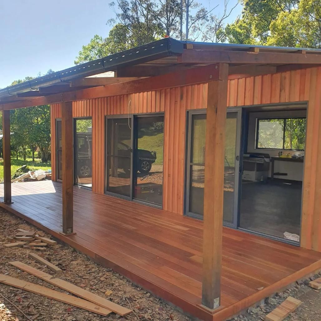 A Small Wooden House With a Porch and Lots of Windows — Offcut Carpentry In Murwillumbah, NSW