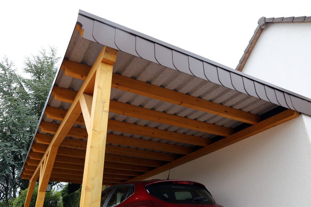 A Red Car is Parked Under a Wooden Carport — Offcut Carpentry In Tweed Heads, NSW