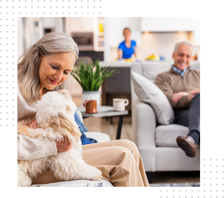 Woman in blue shirt cleans kitchen cabinets with a cloth.