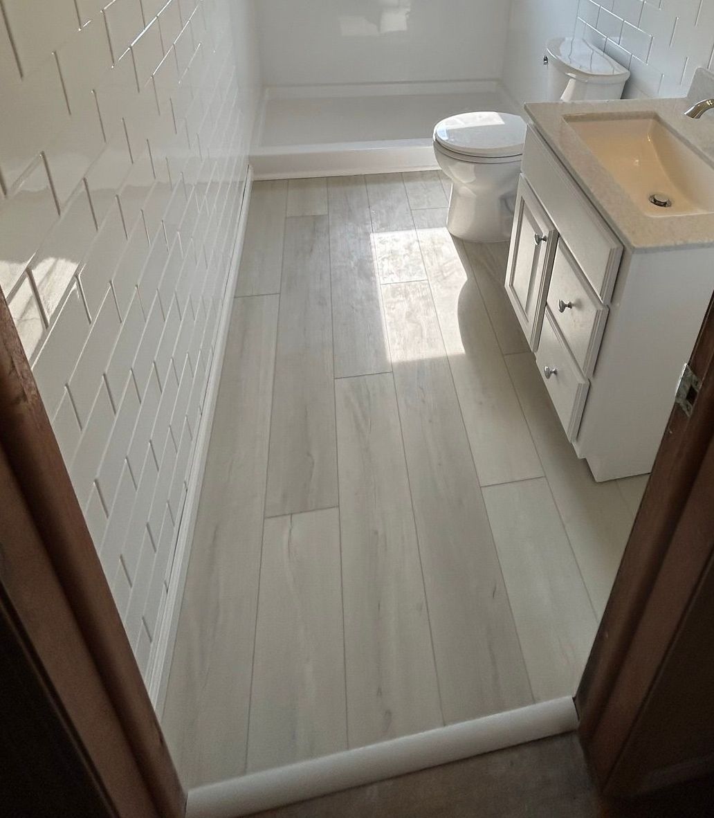 A bathroom with a toilet , sink , and bathtub.