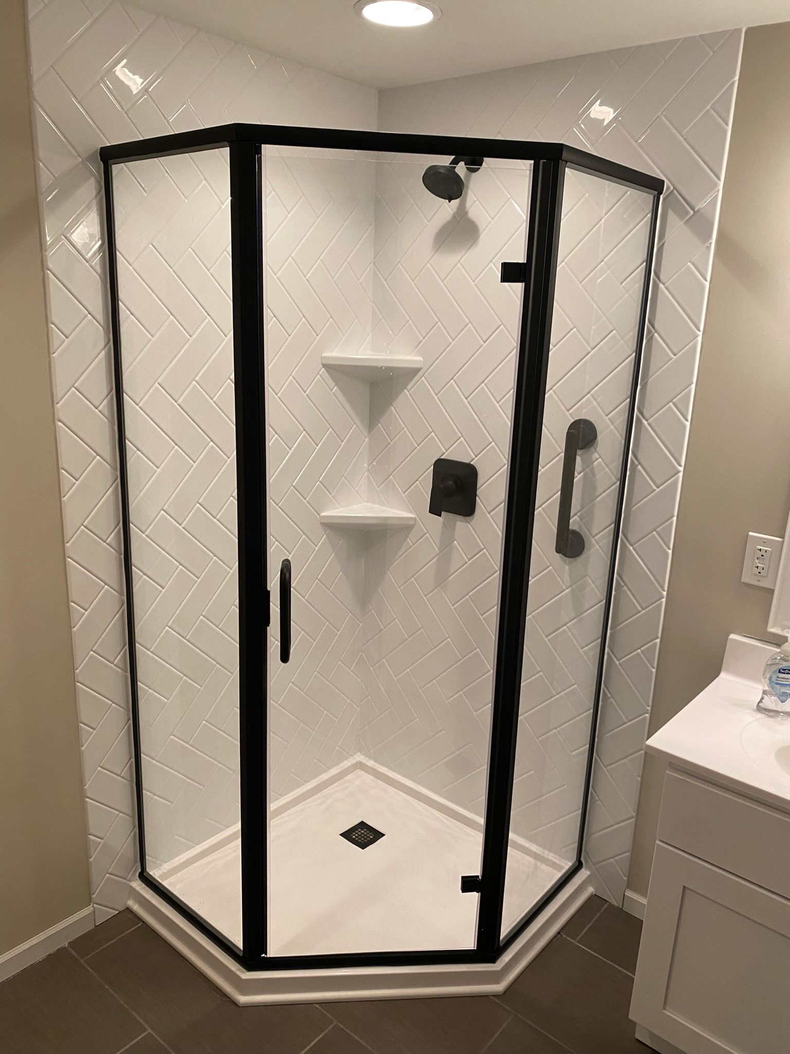 A bathroom with a shower stall and a sink.