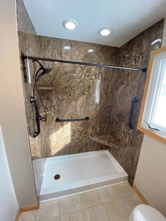 A bathroom with a walk in shower and a toilet.