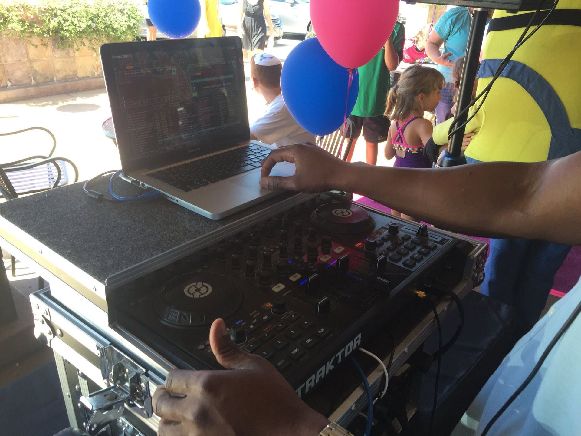 A dj is playing music on a table with balloons in the background