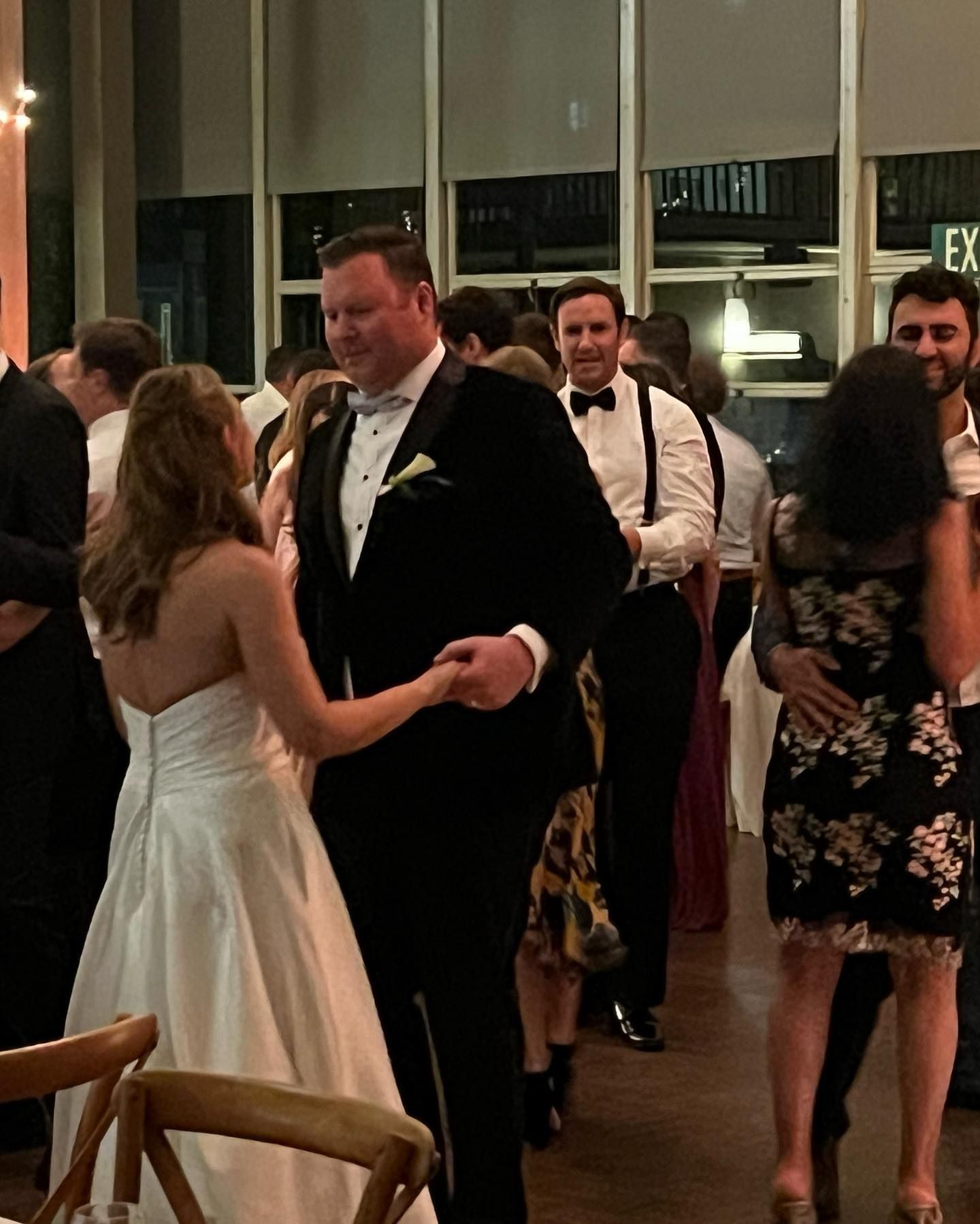 A bride and groom are dancing at their wedding reception