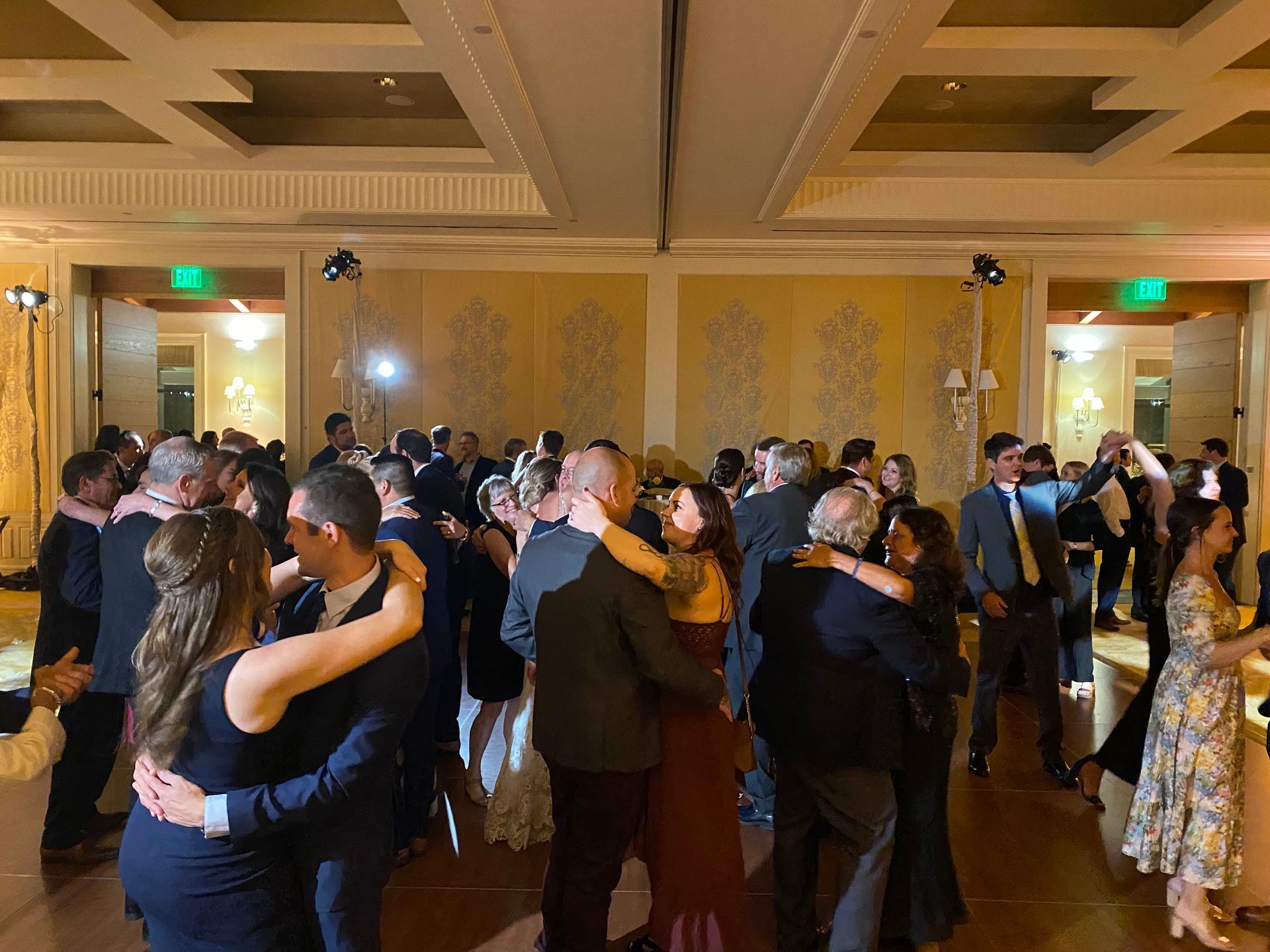 A large group of people are dancing in a large room.