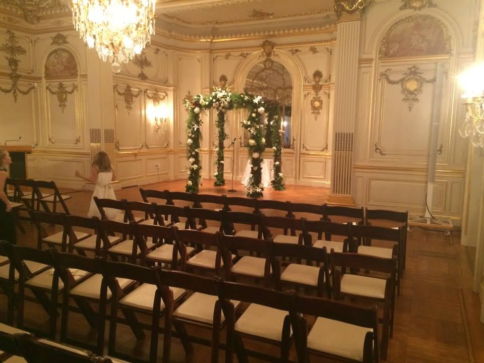 A long hallway with chairs and a mirror on the wall.