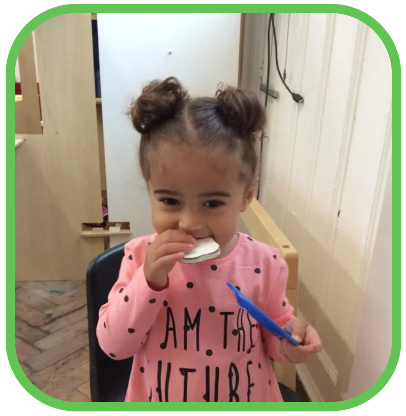 A little girl in a pink shirt that says am the future is brushing her teeth