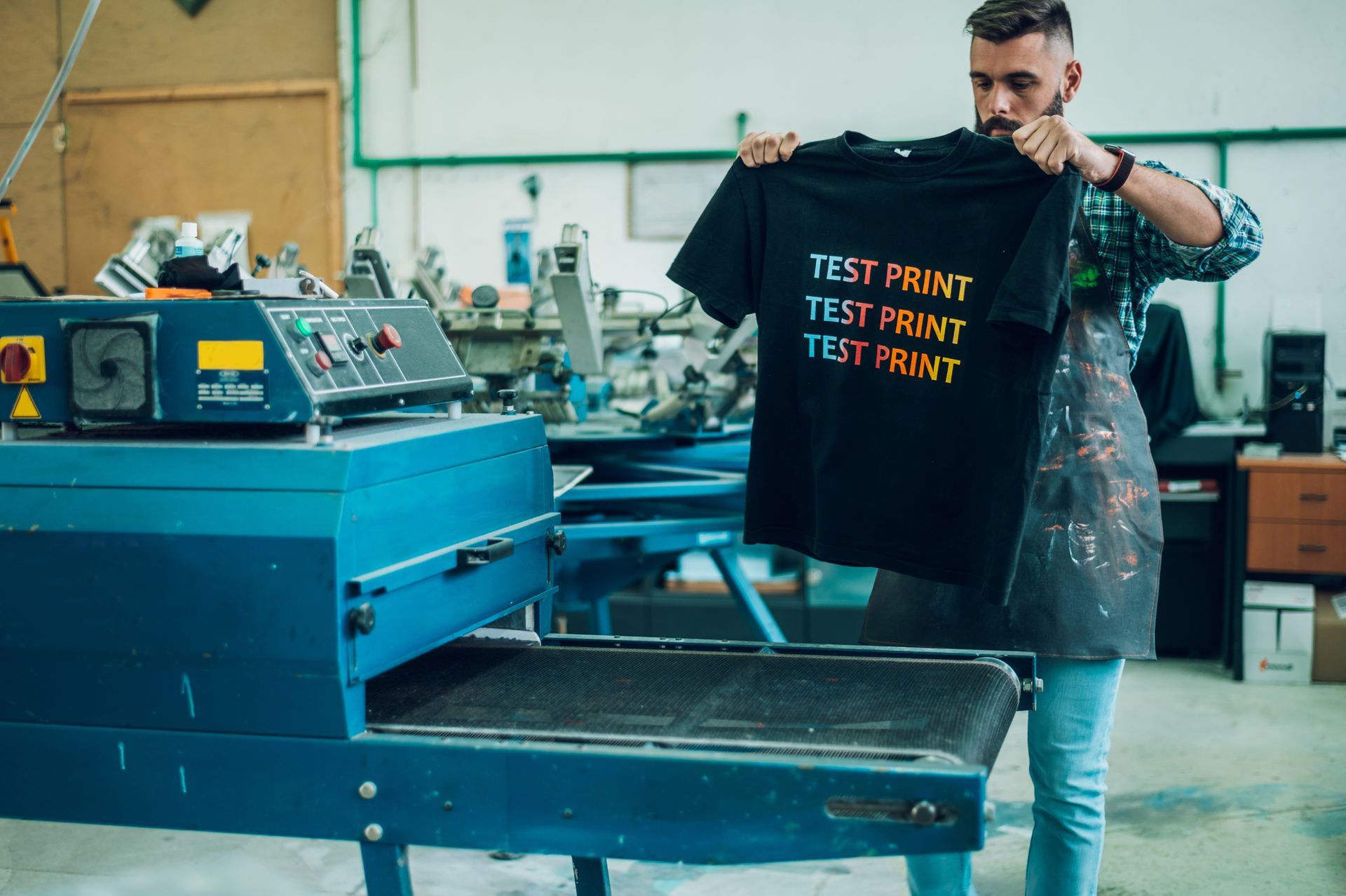 un hombre está usando una máquina de prensado en caliente para hacer una camiseta.