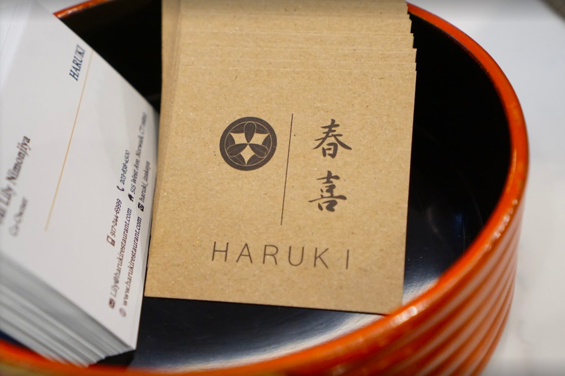 A stack of business cards in an orange bowl;