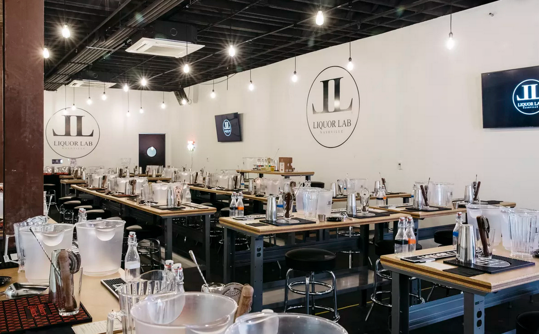 Inside a craft studio, tables are set up for a workshop, logos on the wall.