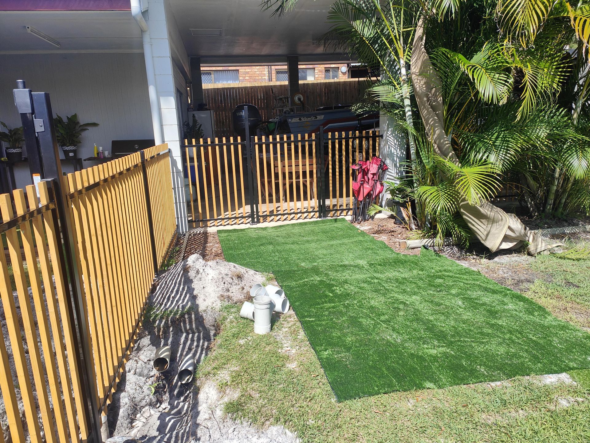 Pathway of artificial grass leading to a gate with a wooden fence alongside a house — Quality Fences 4 U in Gympie, QLD