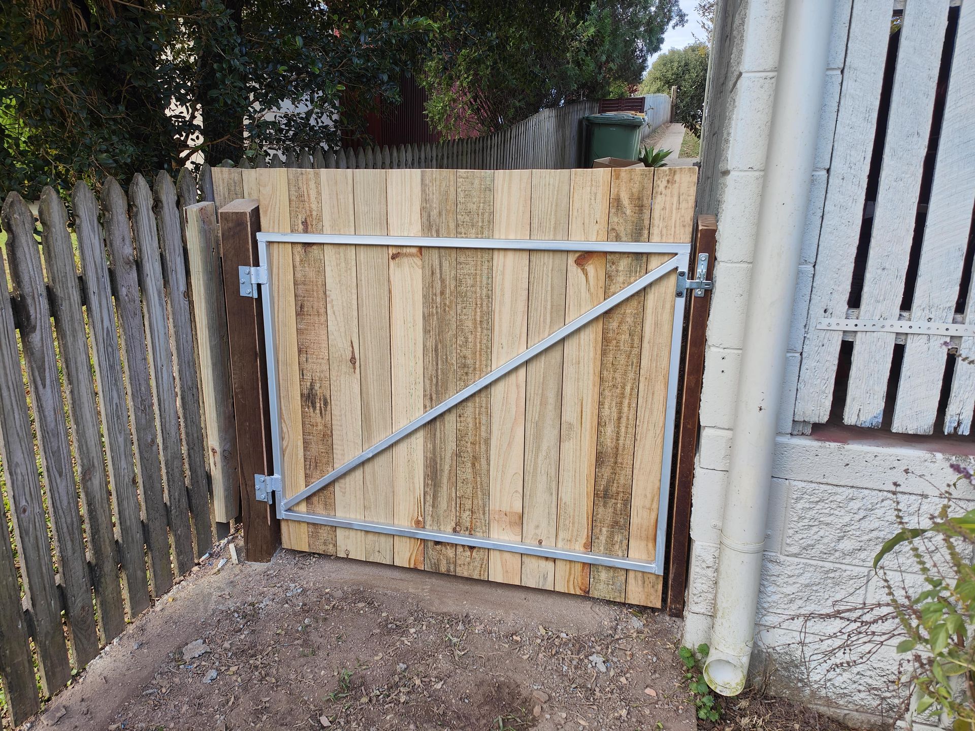 Wooden gate in a fence, with metal frame and diagonal support — Quality Fences 4 U in Gympie, QLD