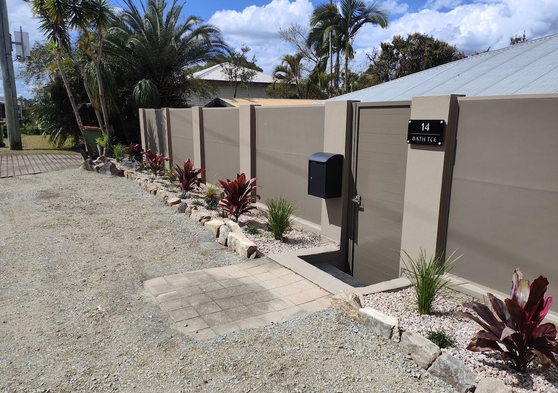 Beige fence with gate, mailbox, and landscaping along a gravel driveway— Quality Fences 4 U in Gympie, QLD
