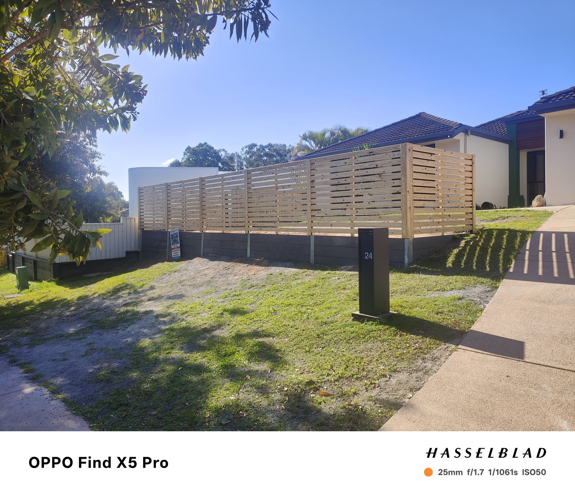 Wooden fence on a small grassy lot next to a house on a sunny day — Quality Fences 4 U in Gympie, QLD