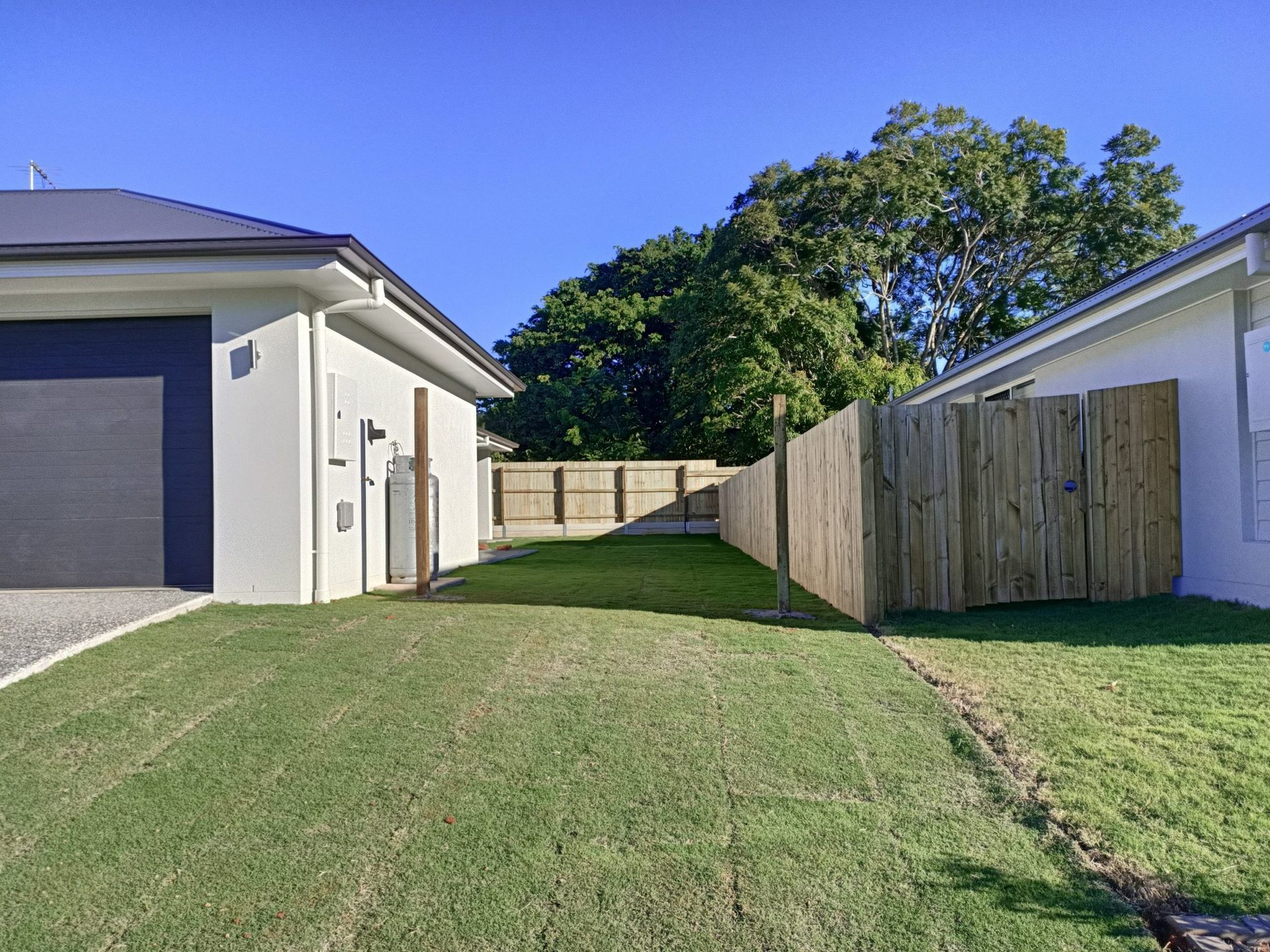Backyard With Green Grass, Wooden Fence — Quality Fences 4 U in Gympie, QLD