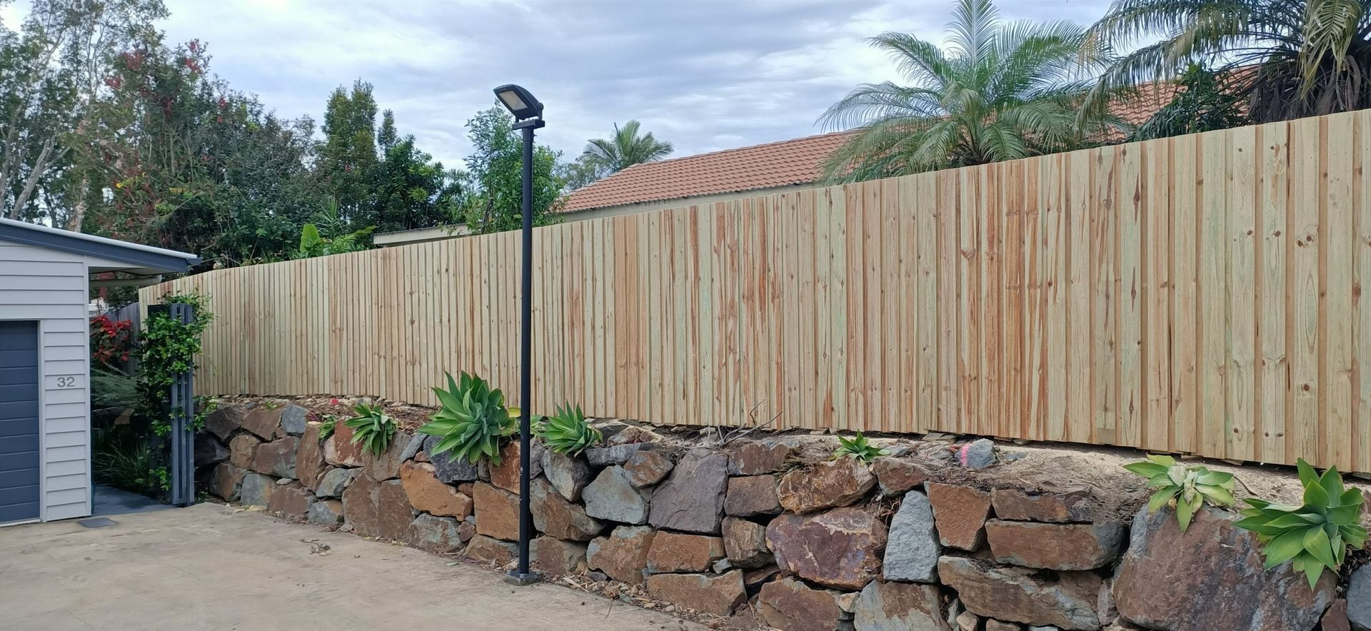Wooden Fence Atop a Stone Wall — Quality Fences 4 U in Tin Can Bay, QLD