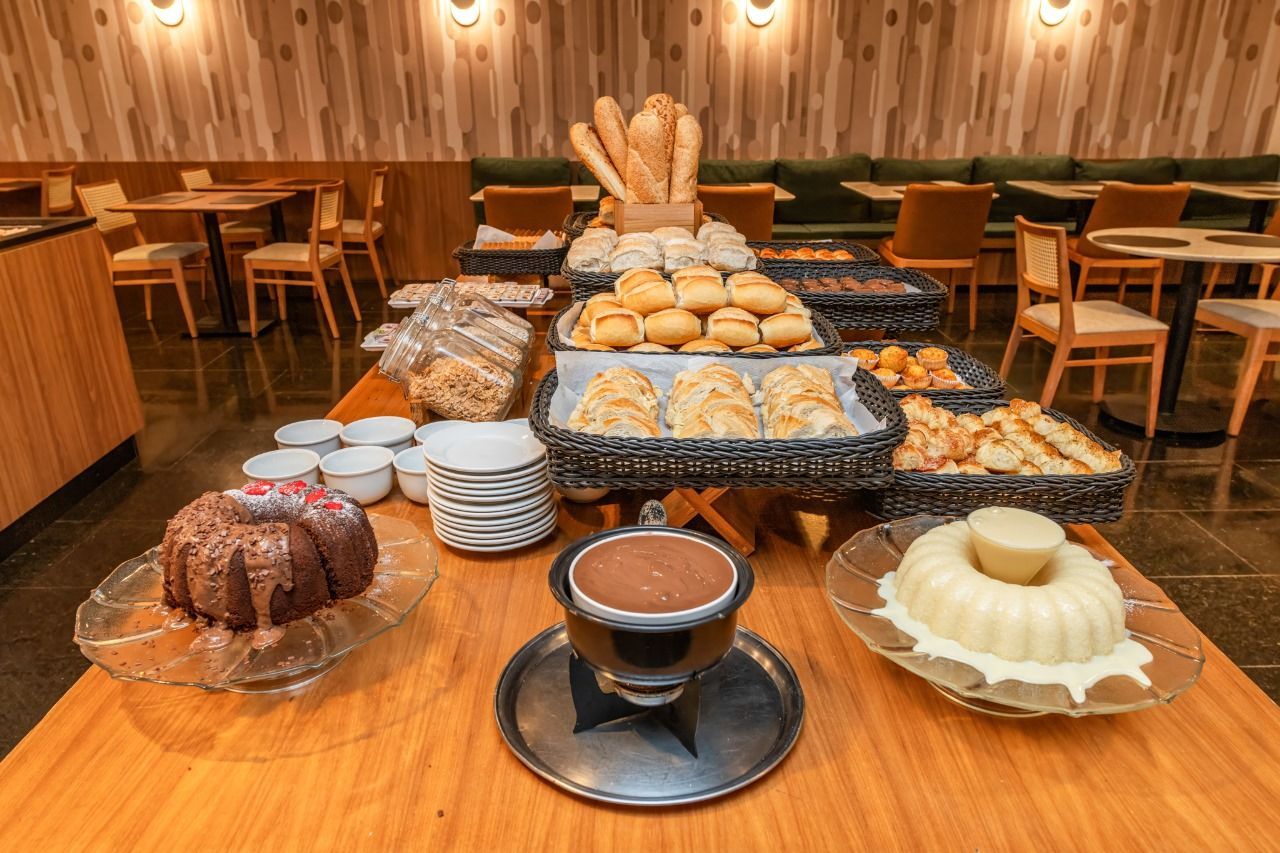 Uma mesa de bufê repleta de uma variedade de pães e doces
