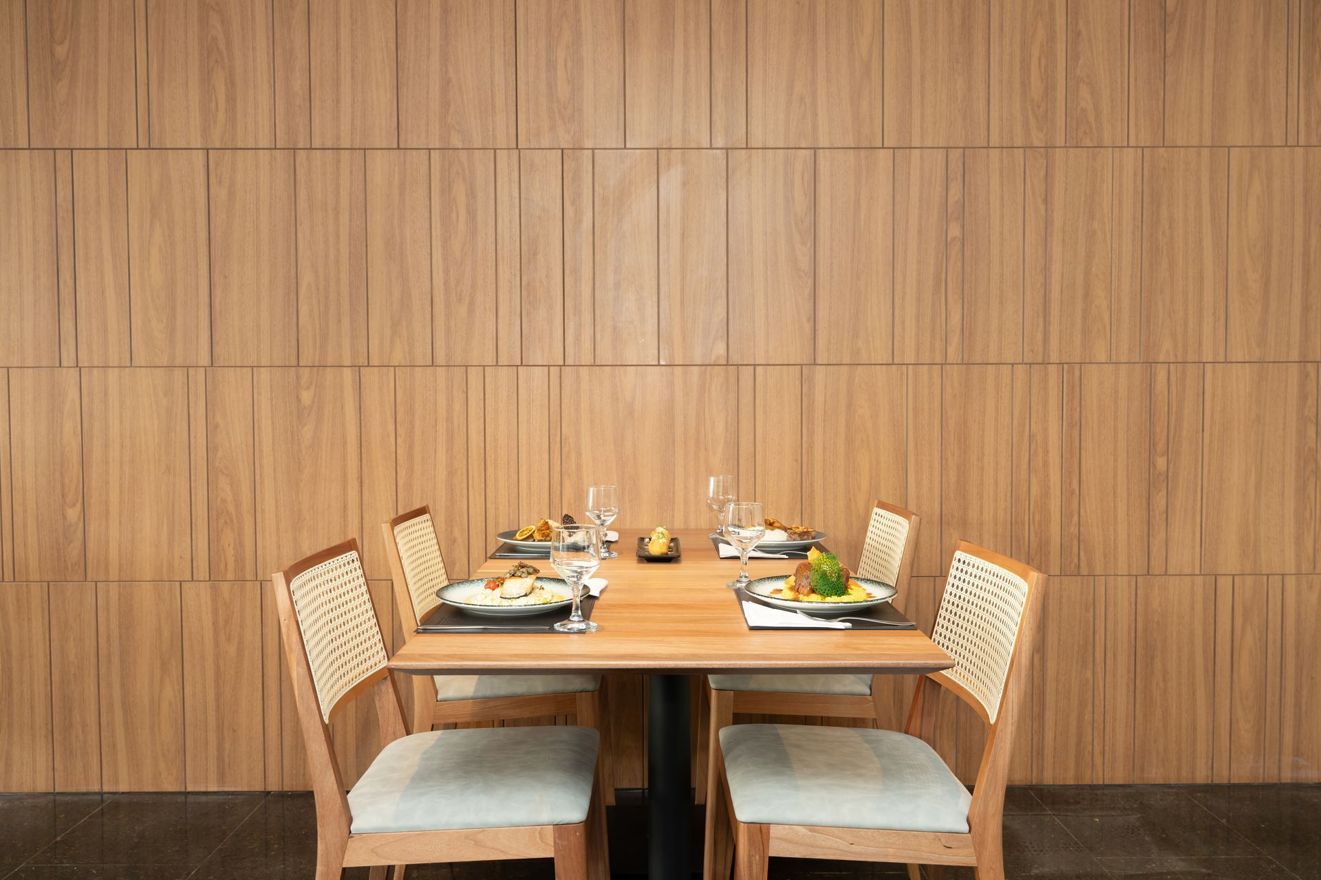 Um restaurante com mesas e cadeiras e uma parede verde