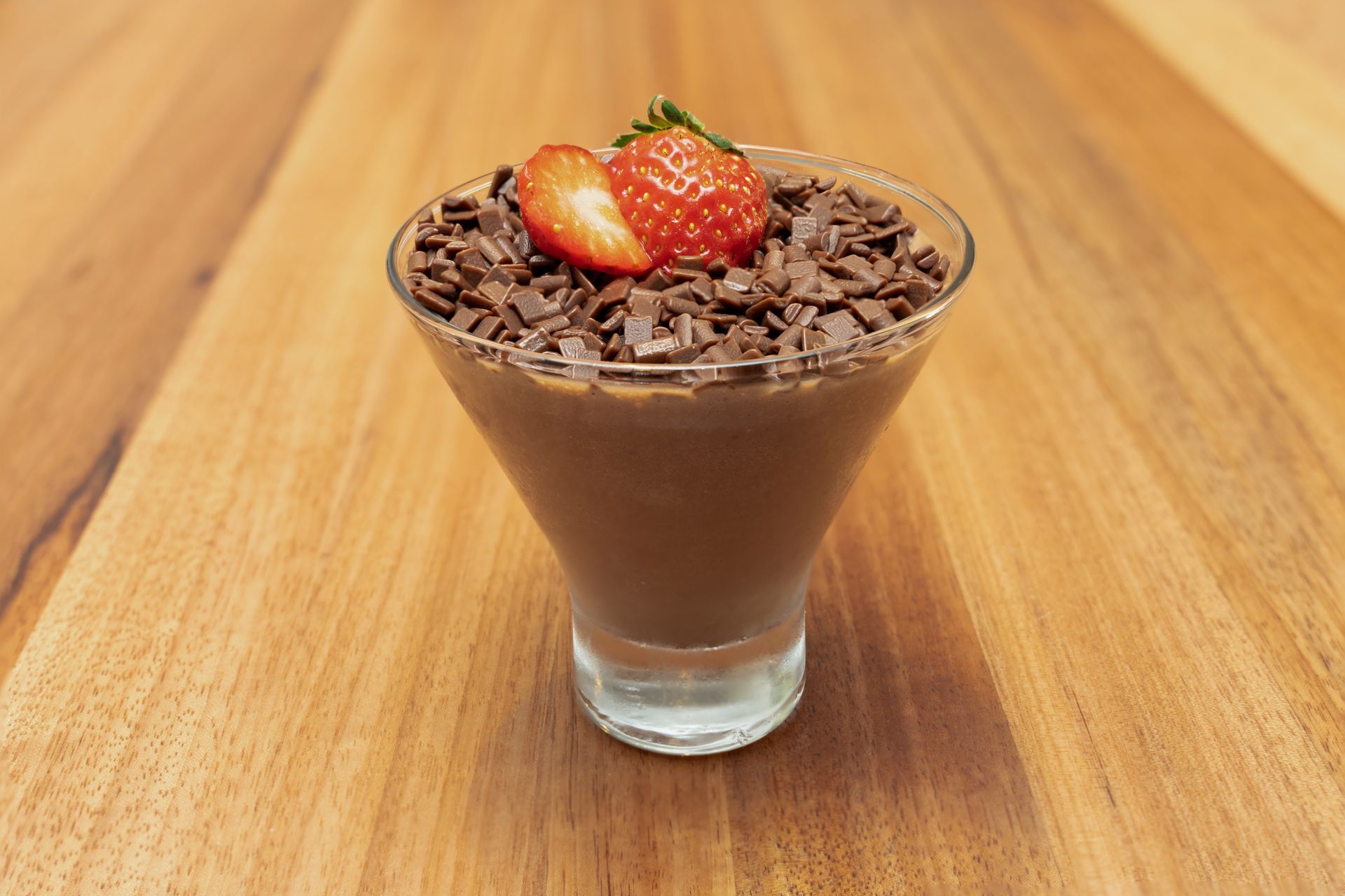 Uma sobremesa em uma taça de martini com morangos por cima