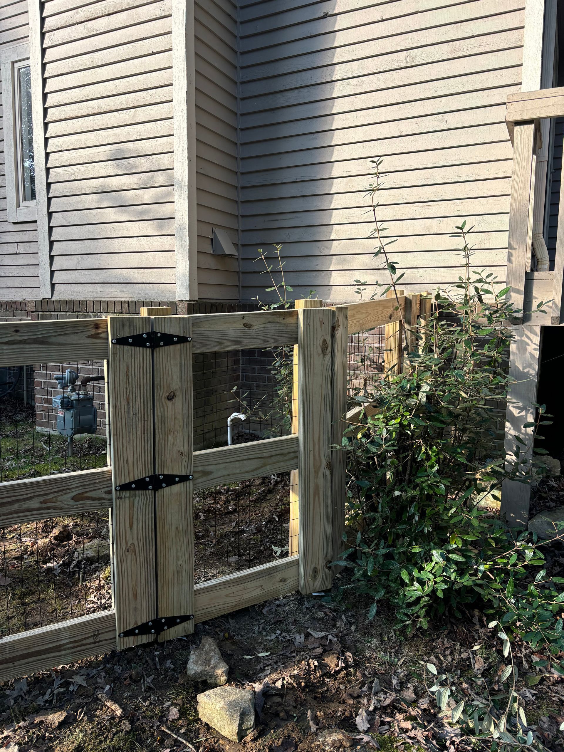 A wooden fence is sitting in front of a house.