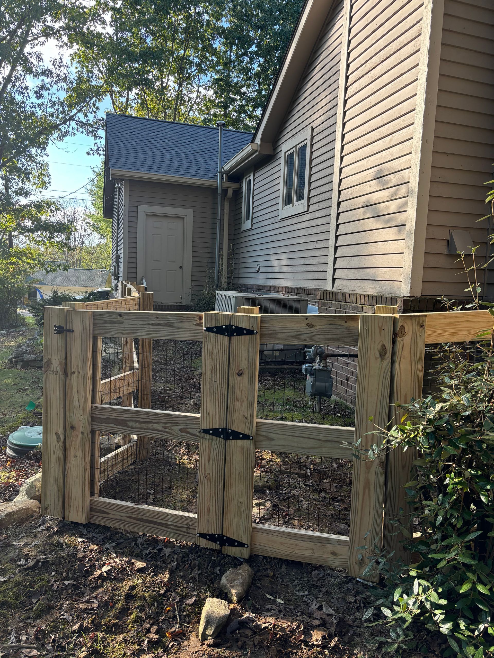 A wooden fence is in front of a house.