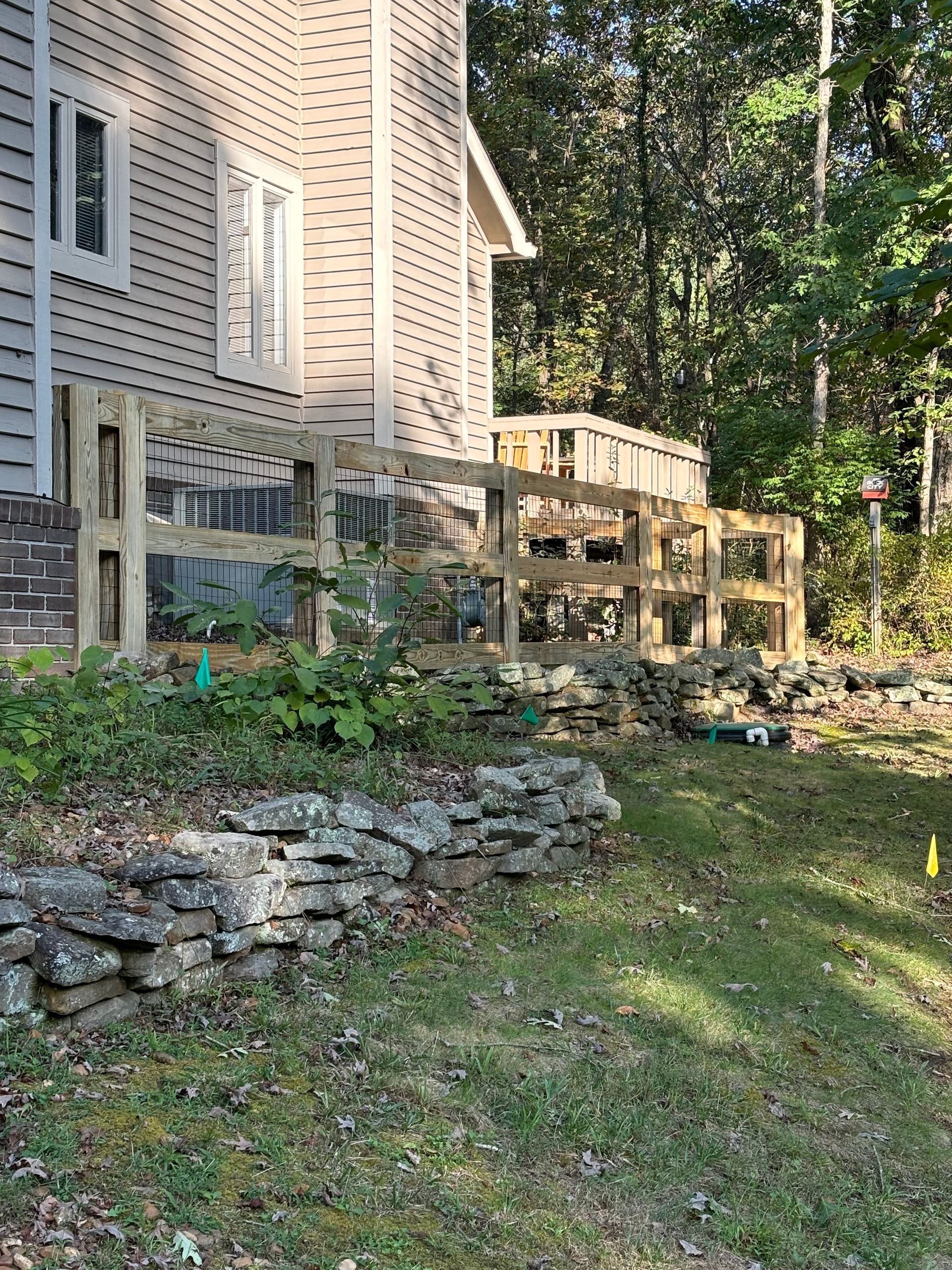 A wooden fence is being built in front of a house.