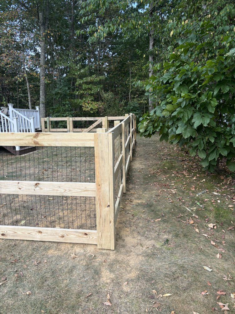 A wooden fence is surrounding a chicken coop in a backyard.