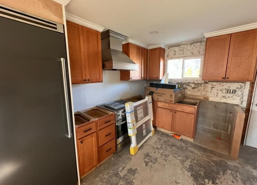 Person using a nail gun to install laminate flooring, indoors.