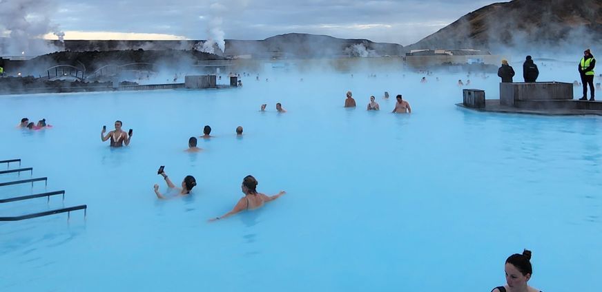 A group of people are swimming in a large pool.