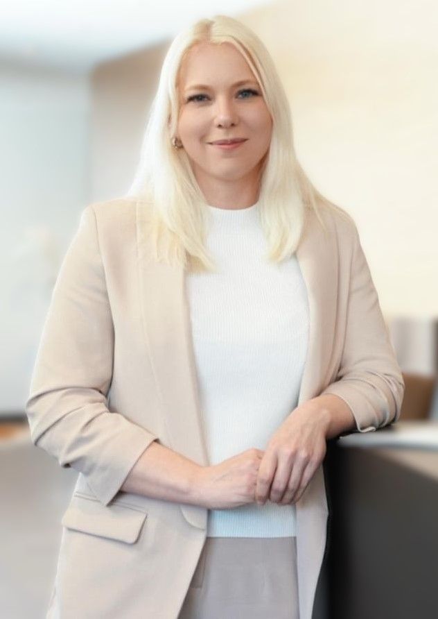 Eine Frau mit langen blonden Haaren lächelt in die Kamera