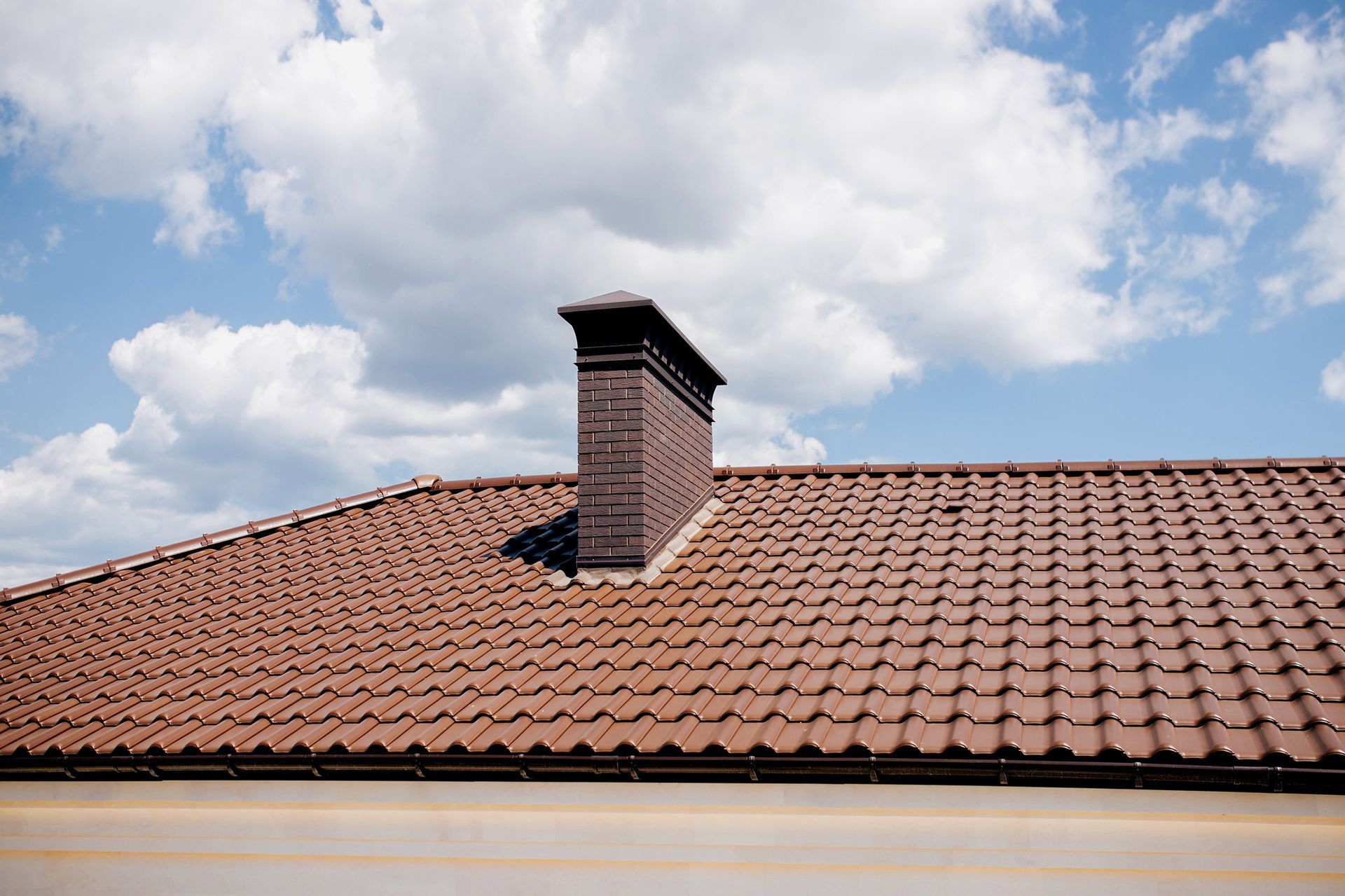 There is a chimney on the roof of a house.