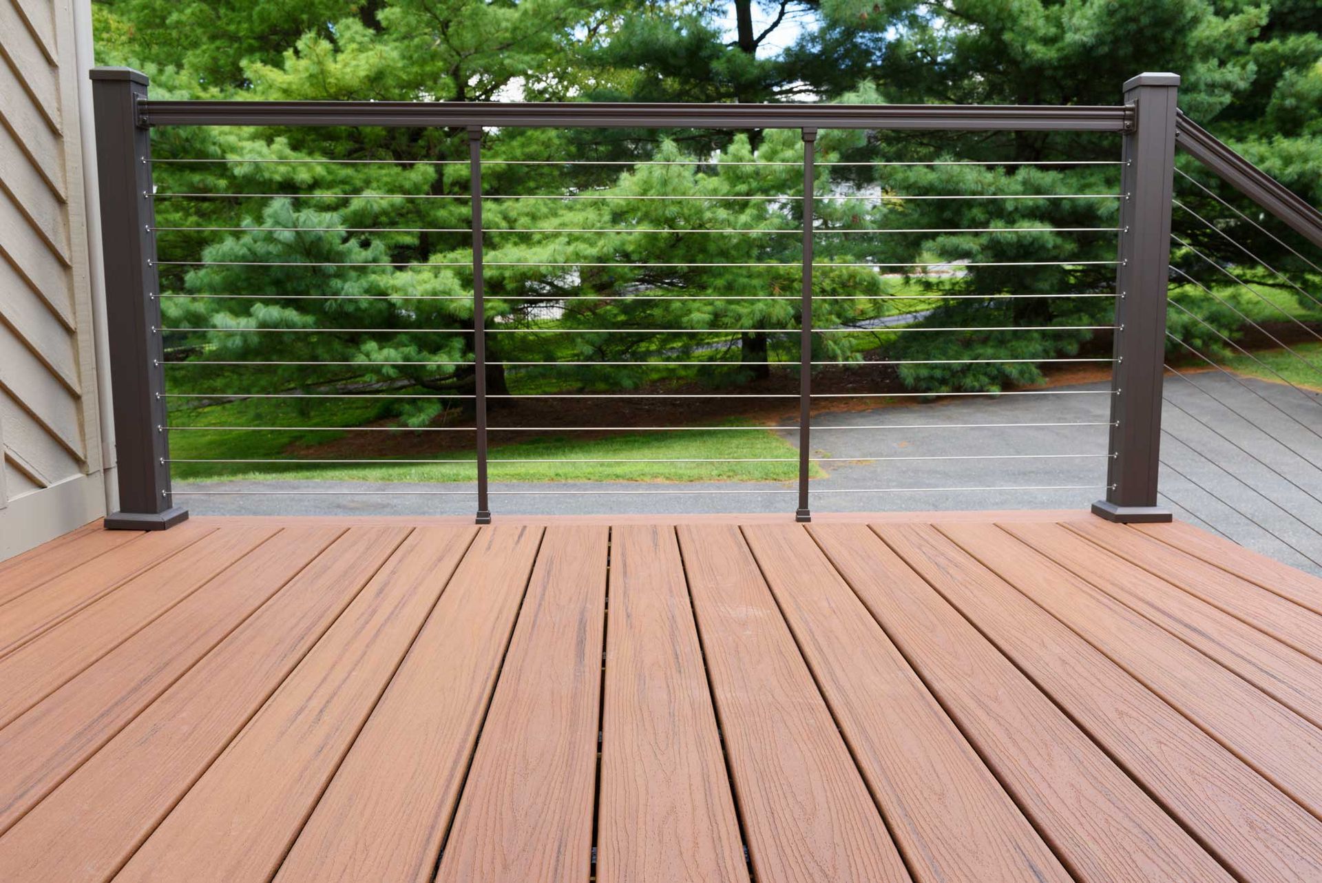 Brown composite deck with bronze railing and cable infill.