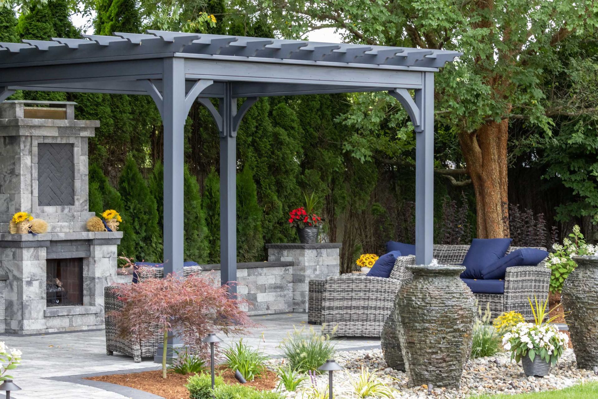 Patio with gray pergola, fireplace, and seating area.