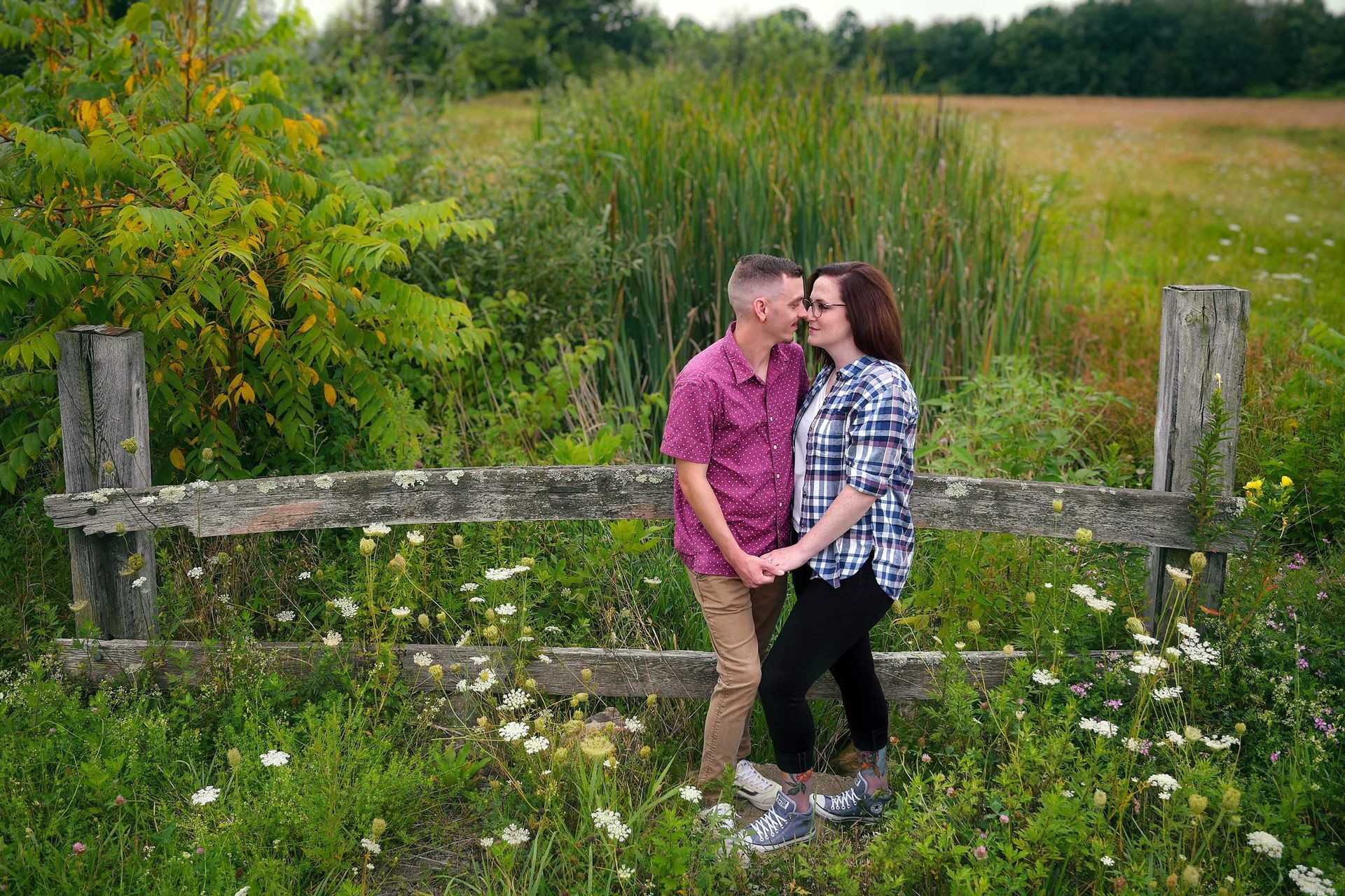 An engagement photo of a couple in a field holding hands in Durham CT for an engagement photo by Rogers Photography.