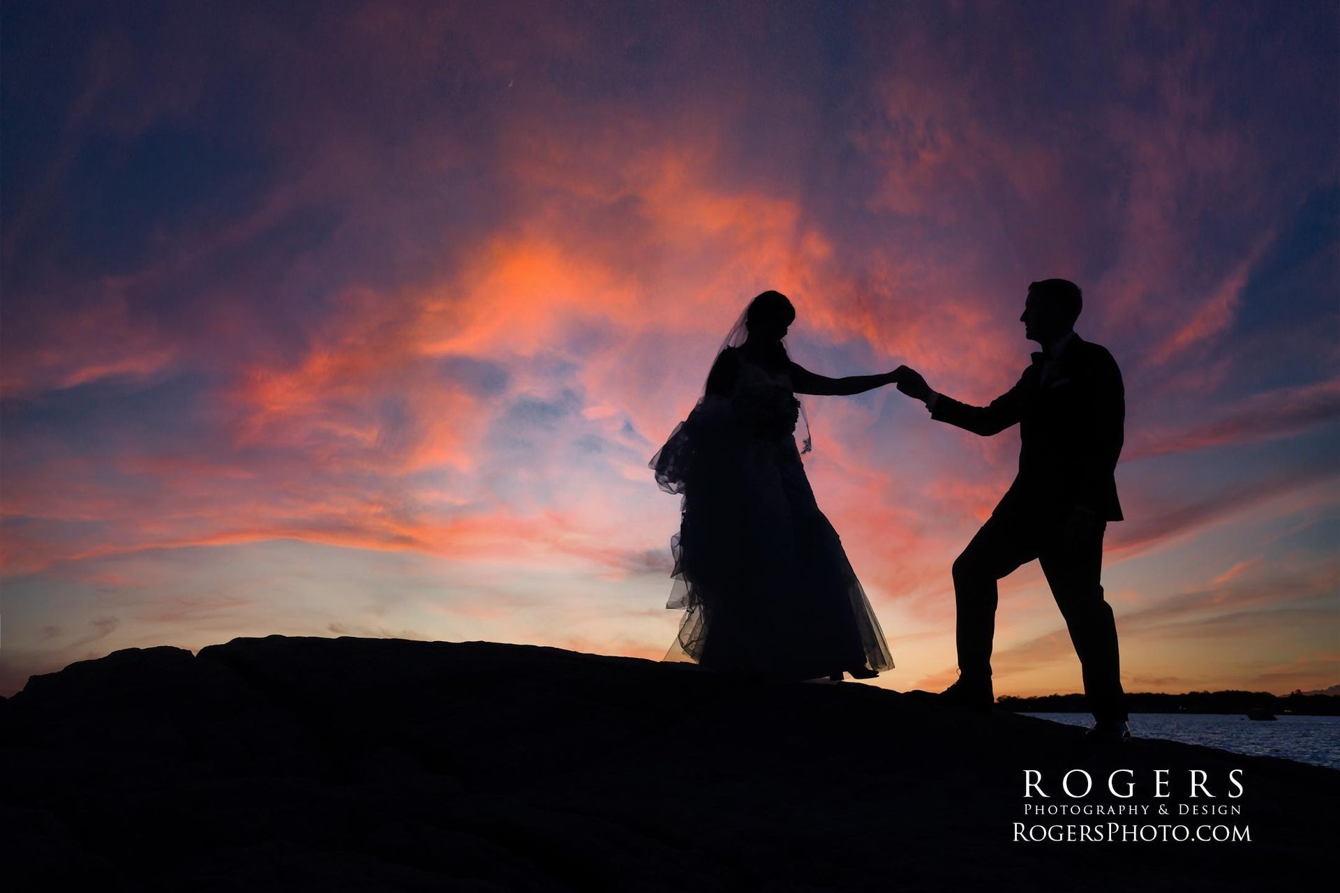 A silhouette of a bride and groom holding hands at sunset at Madison Beach wedding photographed by Rogers Photography in Connecticut.