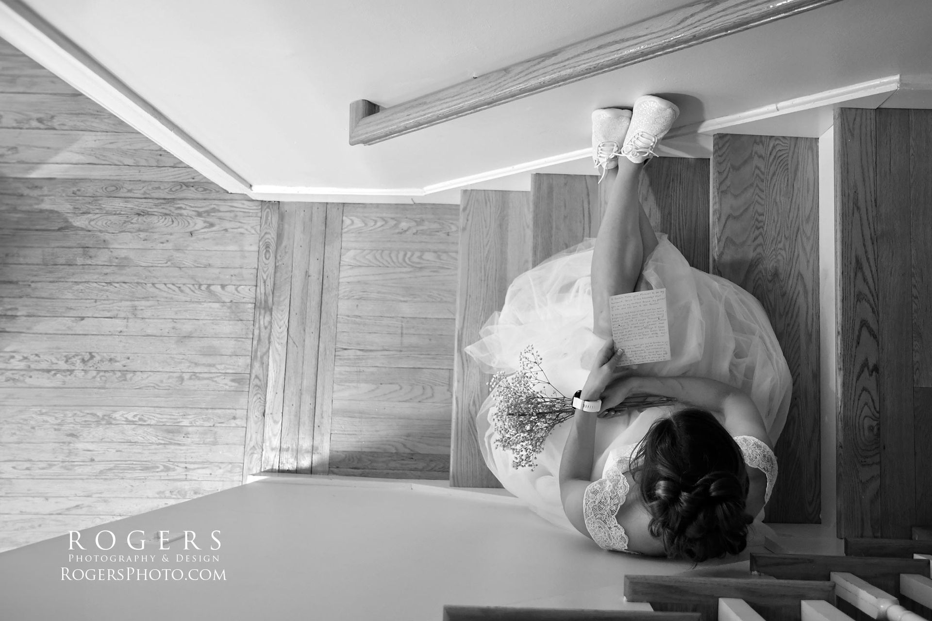 A bride in a wedding dress is laying on a set of stairs wedding photographed by Rogers Photography in Connecticut.