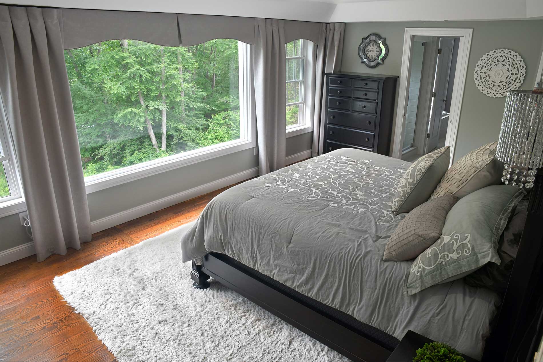 A bedroom with a large bed and lots of windows for Real Estate photography by Rogers Photography.