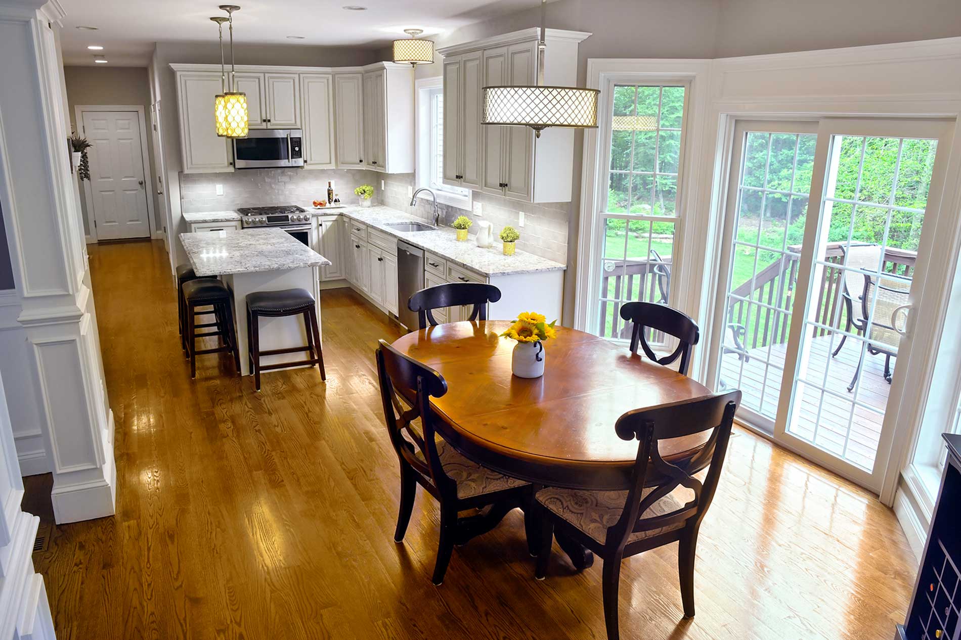 A kitchen with a table and chairs and a sliding glass door for Real Estate photography by Rogers Photography.