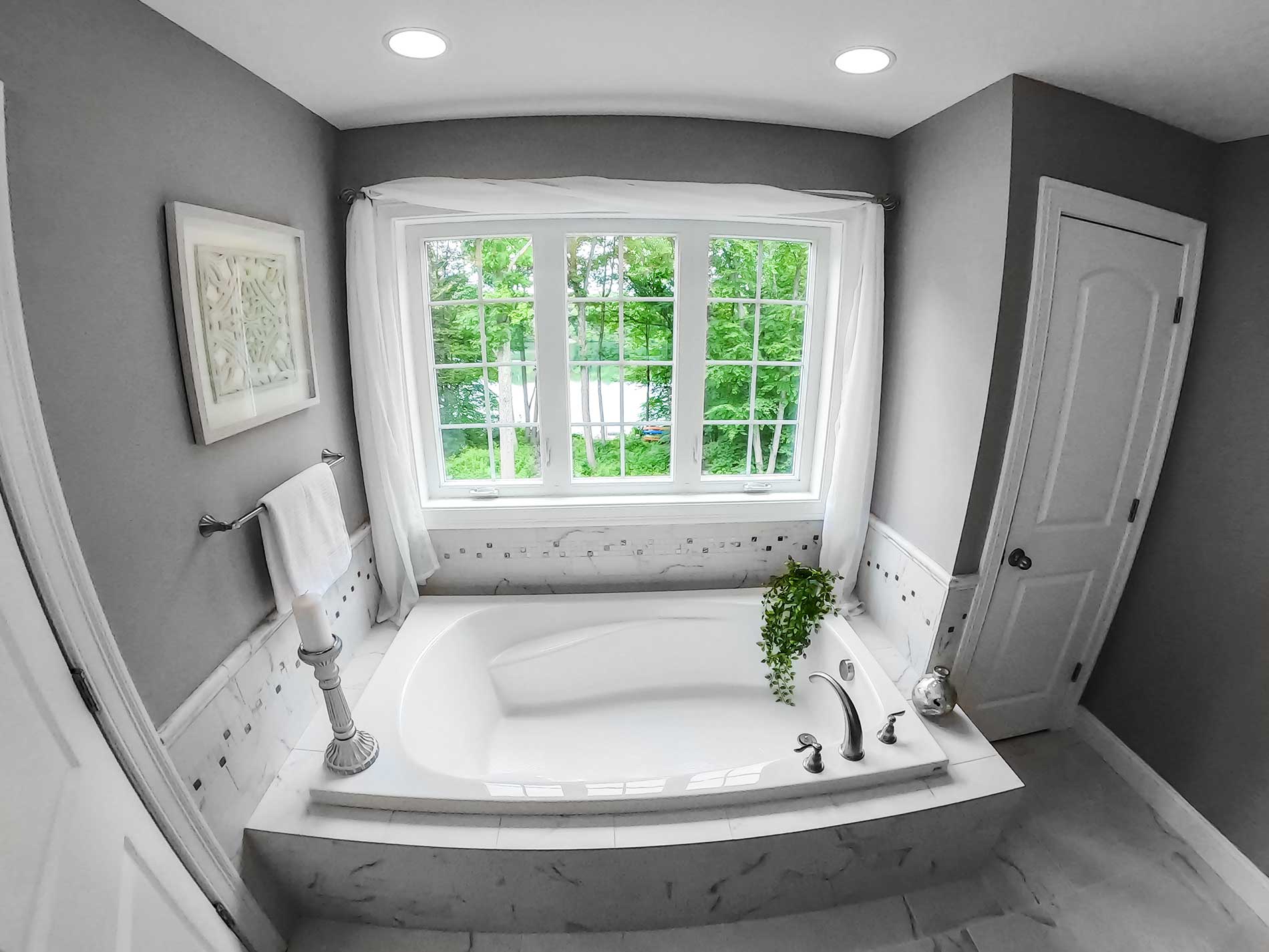 A bathroom with a large tub and a window for Real Estate photography by Rogers Photography.