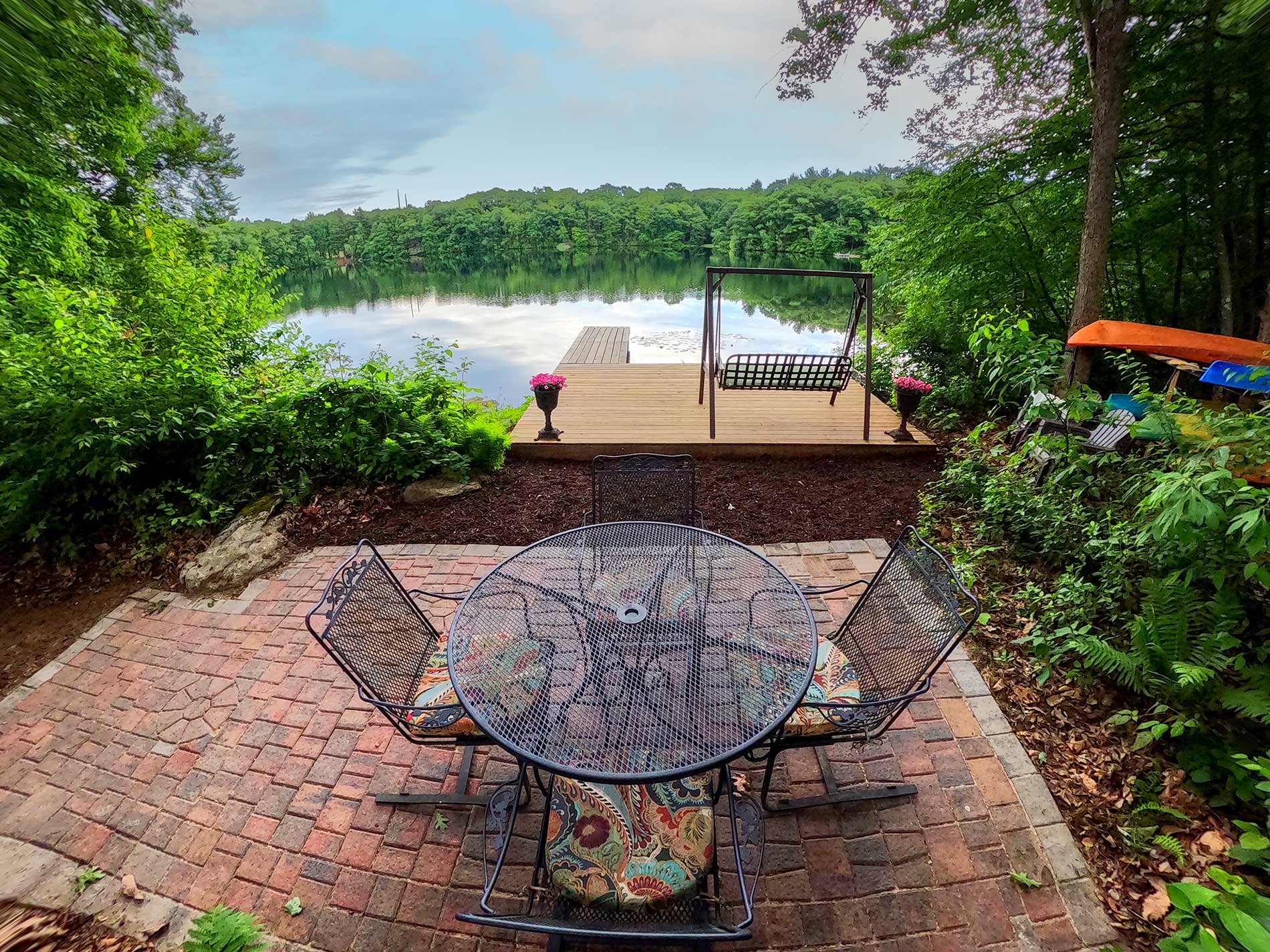 A patio with a table and chairs overlooking a lake for Real Estate photography by Rogers Photography.