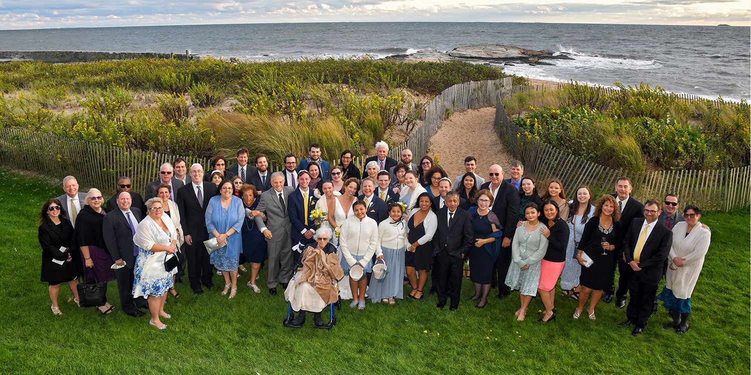 A photograph of a wedding group of people at a reception at Madison Beach Hotel wedding photography by Connecticut Photographers Rogers Photography